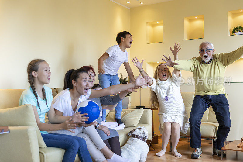 幸福的家庭成员在一起看足球比赛度过美好的时光。