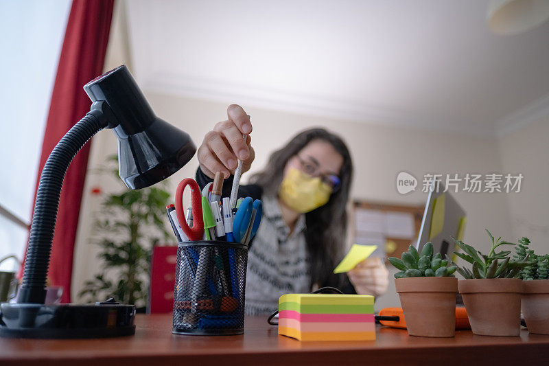 戴口罩在办公室工作的妇女