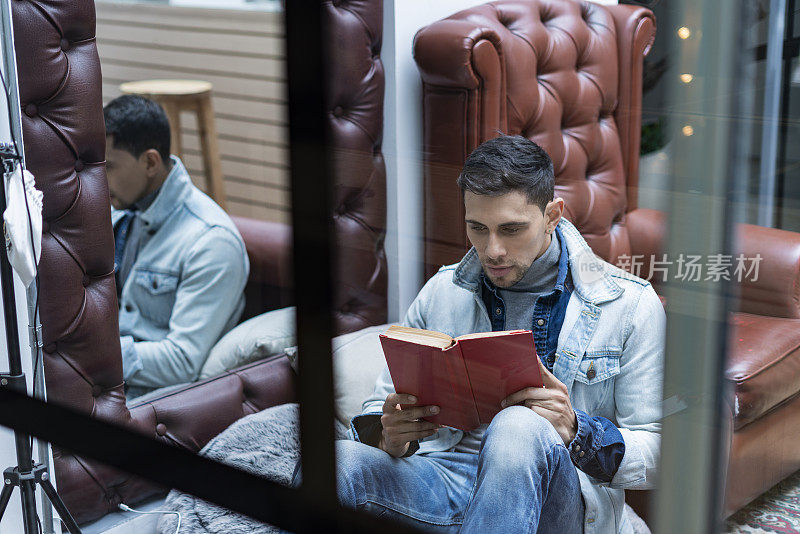 一名拉丁裔男子在家里全神贯注地看书