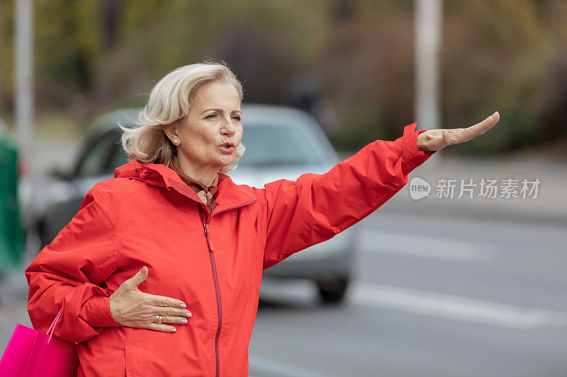 一个妇女的肖像谁是站在城市的街道和试图赶上一程。
