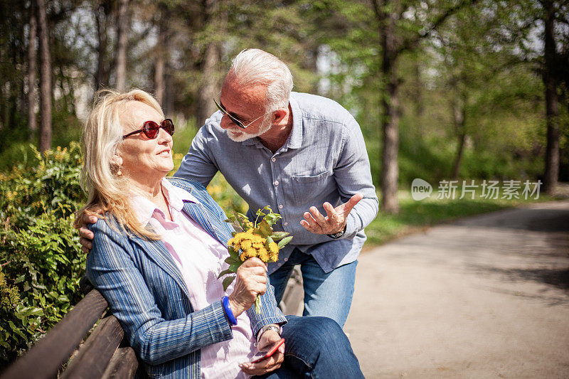 微笑的成熟夫妇花时间在公园。