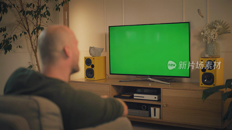 在家看屏幕的时间。男人一边看电视一边放松。屏幕上的色度键