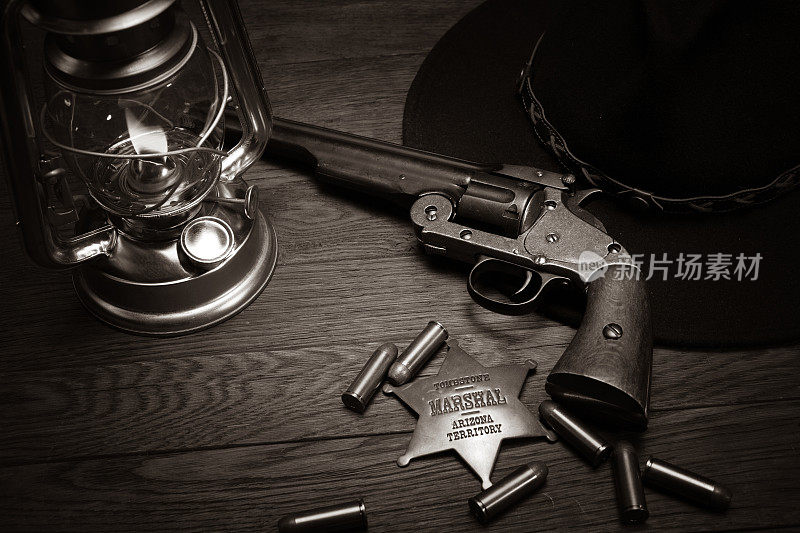老西部场景-冷风灯，元帅徽章和带子弹的左轮手枪