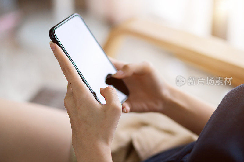 特写图像，女人在智能手机屏幕上打字。