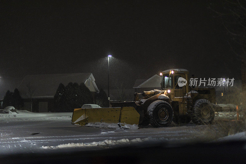 前装载机扫雪机在夜间暴雪停车场等待