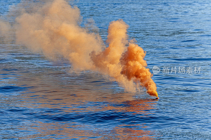 蓝色大海里的一枚橙色烟雾弹。遇险信号