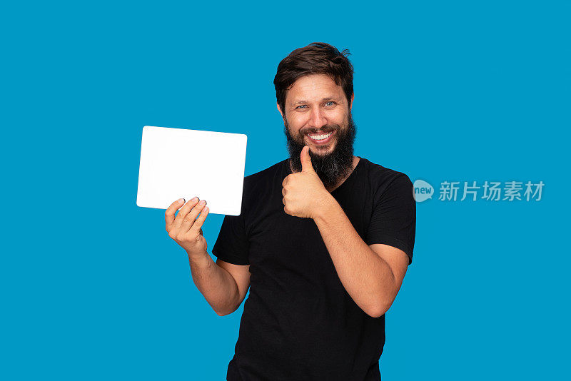 微笑的男人的肖像，拿着数码平板电脑的蓝色背景