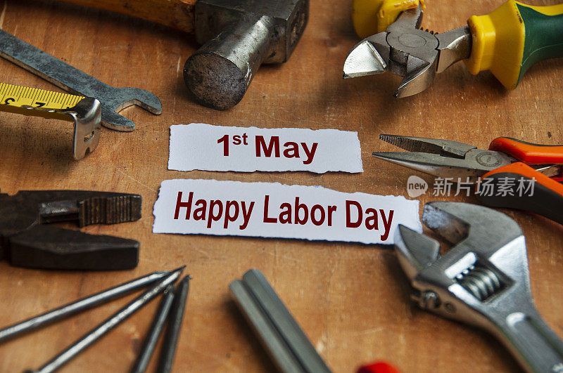 劳动节快乐的文本撕碎的文件与工作工具的背景。劳动节庆祝理念。