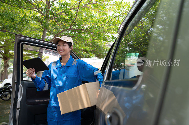 中年亚洲华人女性快递员与包装纸板箱