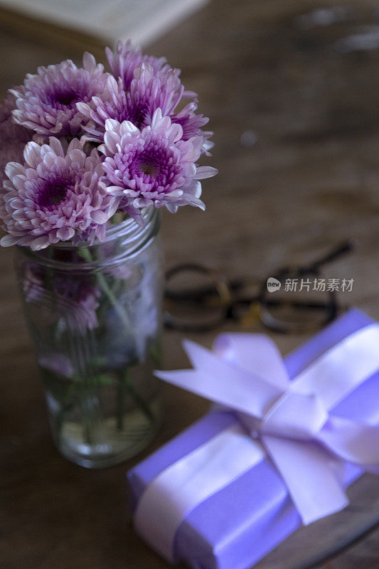 桌子上装饰着礼物和菊花紫罗兰