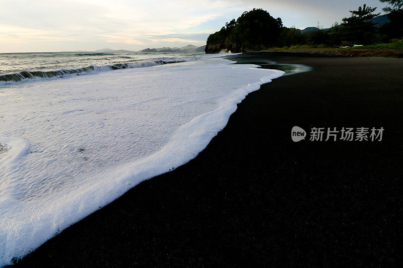 白色的海浪和黑色的沙滩