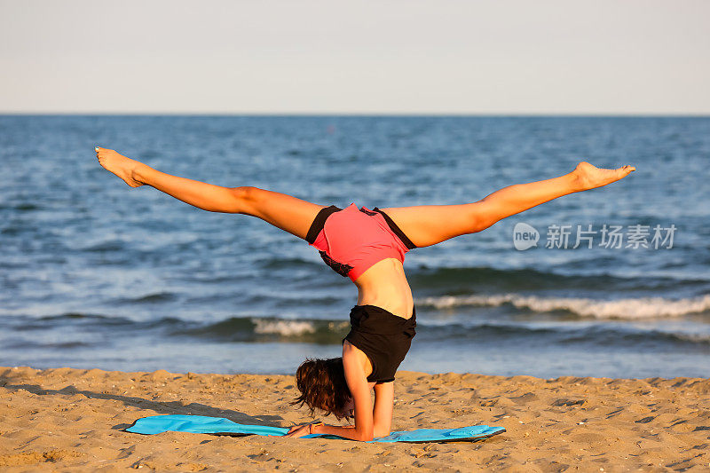十几岁的女孩低着头在海边做体操