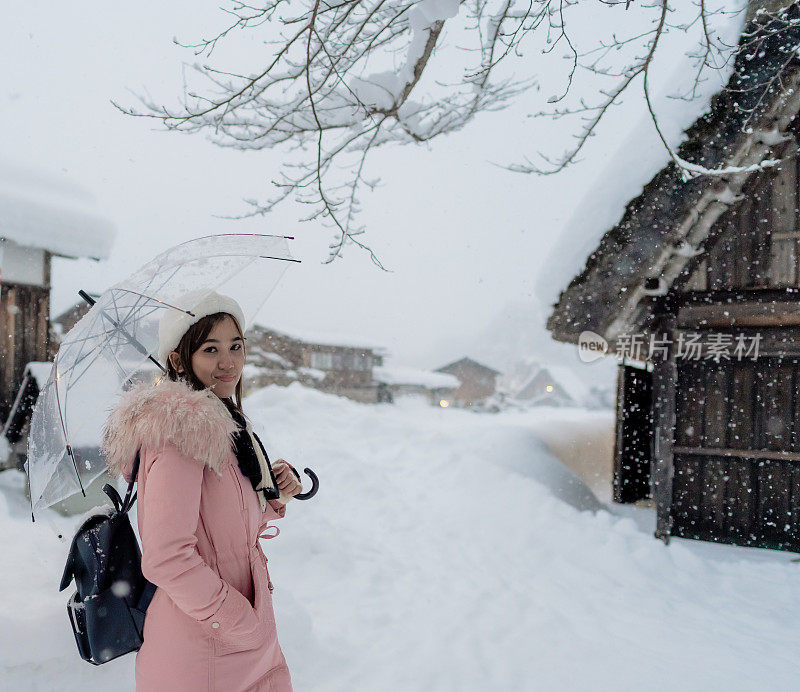 美丽的女游客们享受着白川村的旅行，冬天的日本有厚厚的积雪