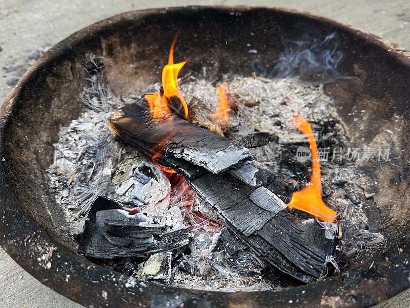 卡代(印度火碗)的全帧图像与舞蹈的火焰，灰烬和烟雾，燃烧的木材余烬，高架视图，重点在前景