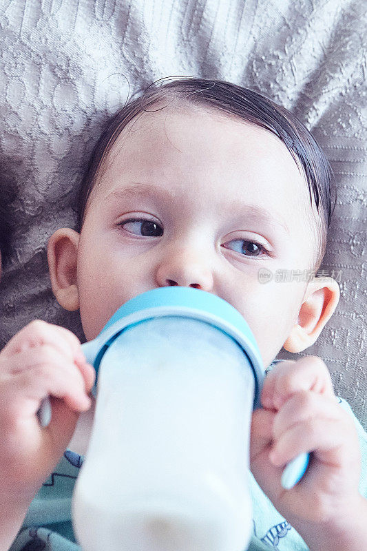 蹒跚学步的孩子用奶瓶喝牛奶