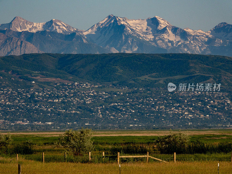 白雪覆盖的瓦萨奇山脉隐藏在盐湖城森特维尔郊区的山坡后面。