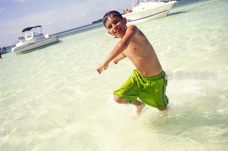 小男孩在海滩上享受清澈的海水