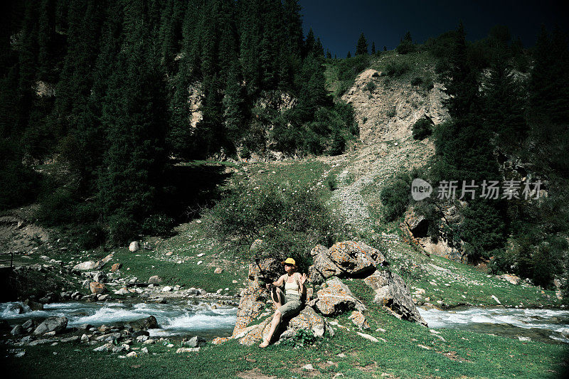 女游客正在展示南天山狭窄峡谷中的大山河