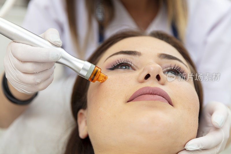 美容师正在为病人的脸部做皮肤护理。