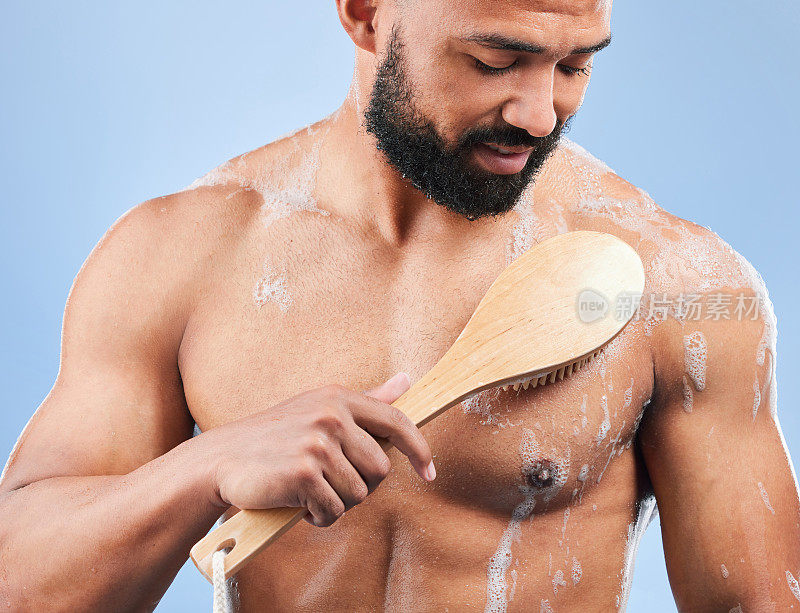 男人，淋浴和刷子在工作室清洁腋窝，擦洗和思考卫生的蓝色背景。人，家伙和泡沫的水疗，化妆品和健康的身体，皮肤护理和健康