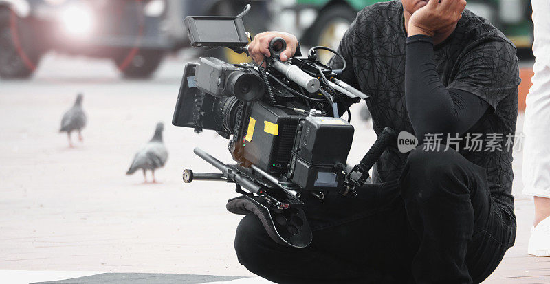 高清晰度摄像机和镜头在稳定的设备支持上的模糊图像，如万向节稳定或稳定的肩架和pan倾斜移位头三脚架，用于在户外拍摄电视商业生产中的快速移动物体。