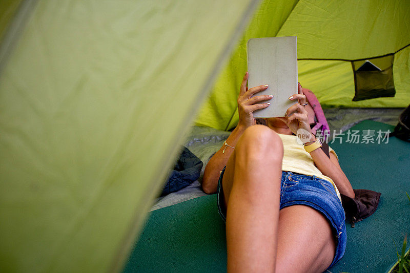 成年女性在露营时使用数字平板电脑