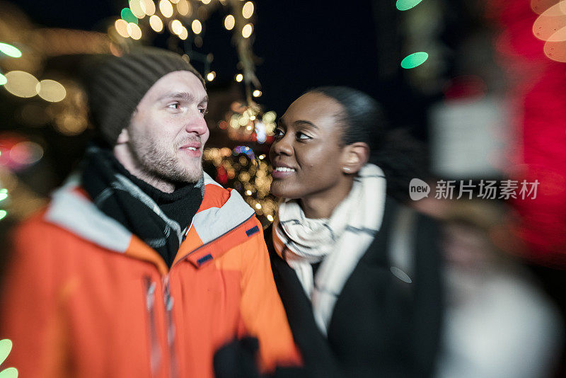 跨种族的相爱的夫妇，美丽的黑人年轻女子和英俊的年轻男子，在纽约布鲁克林观看圣诞彩灯和在寒冷的冬日里玩耍。