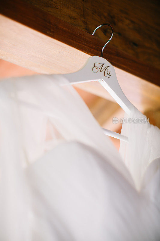 白色的婚纱挂在木衣架上与夫人措词
