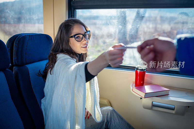 享受旅行。年轻漂亮的女人乘火车靠近窗户。火车的概念。