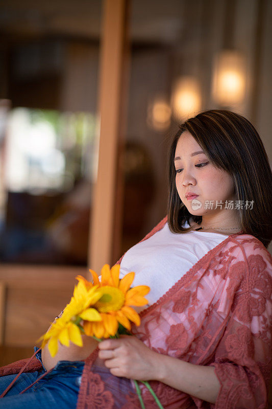 怀孕少女在木制露台休息