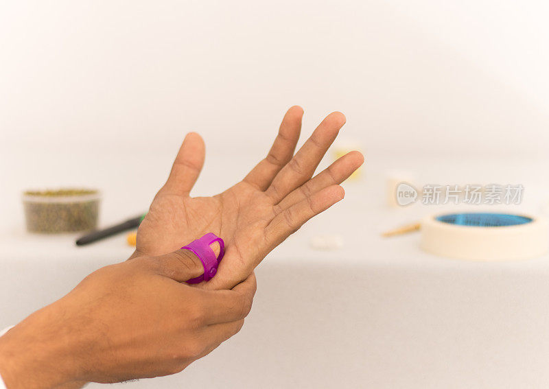Sujok或指压疗法，在孤立的背景下用Sujok按摩器对手指施加压力。