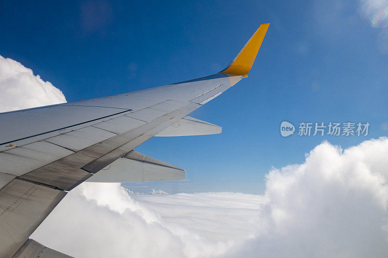 飞机的机翼在天空的云上面飞行