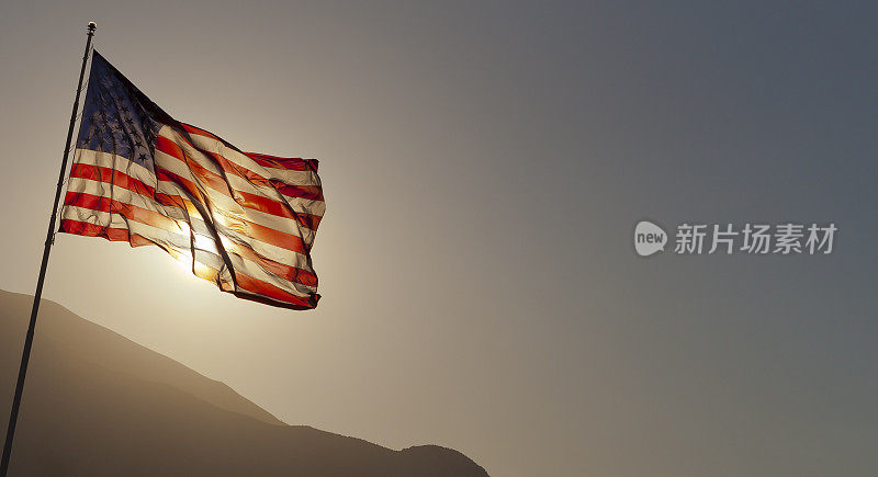 背光的美国国旗飘扬在有拷贝空间的杆子上。