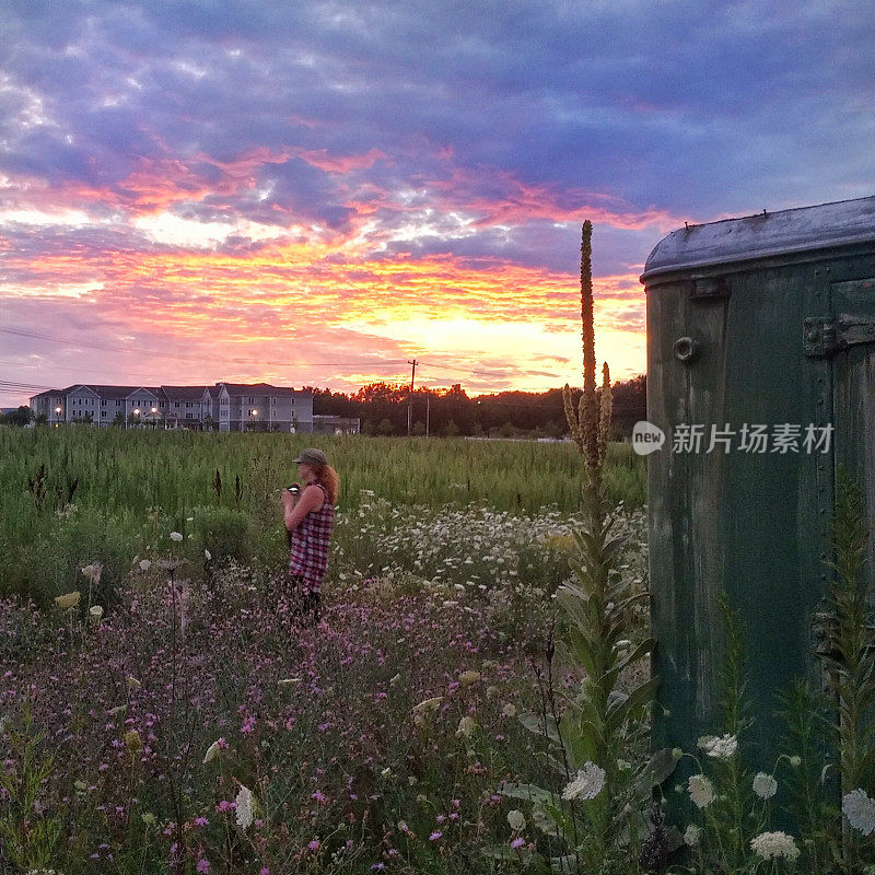 女摄影师，野花田，日落黄昏的天空