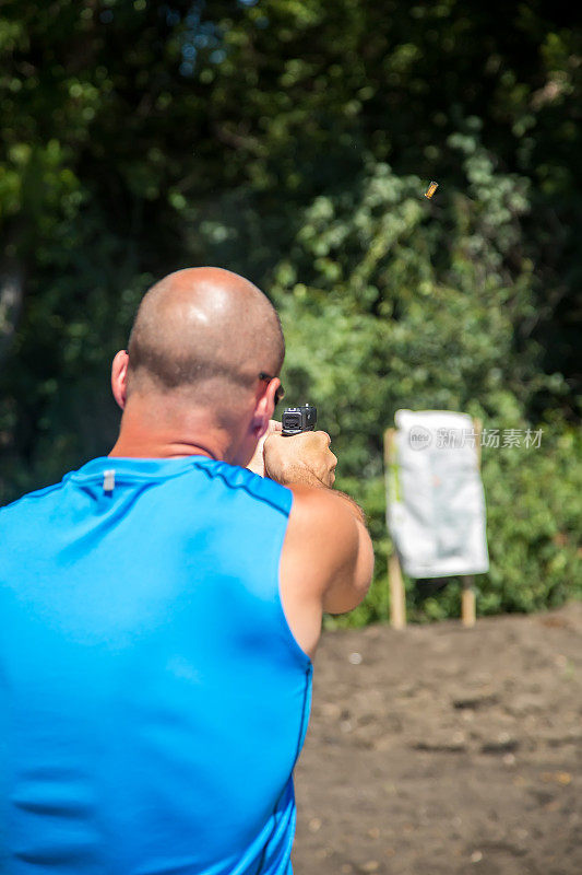 一名男子在外面用手枪射击自制目标