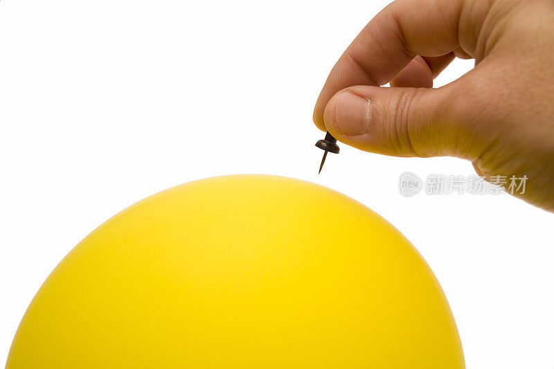 一只手准备用别针刺破气球以引起意外