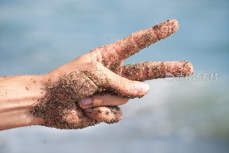 好吧，在沙滩上用沙质手做个手势
