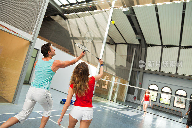 年轻人在体育馆打羽毛球