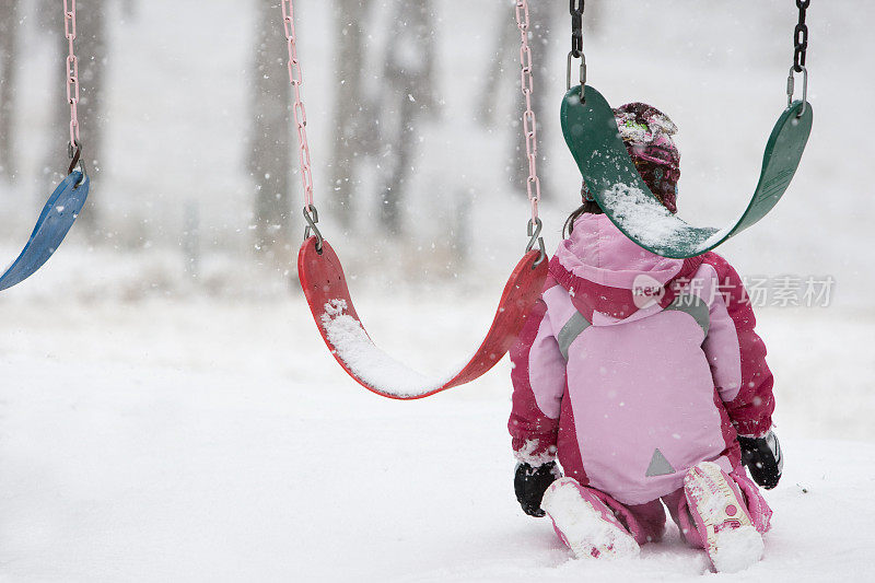 一个小孩子跪在雪地里