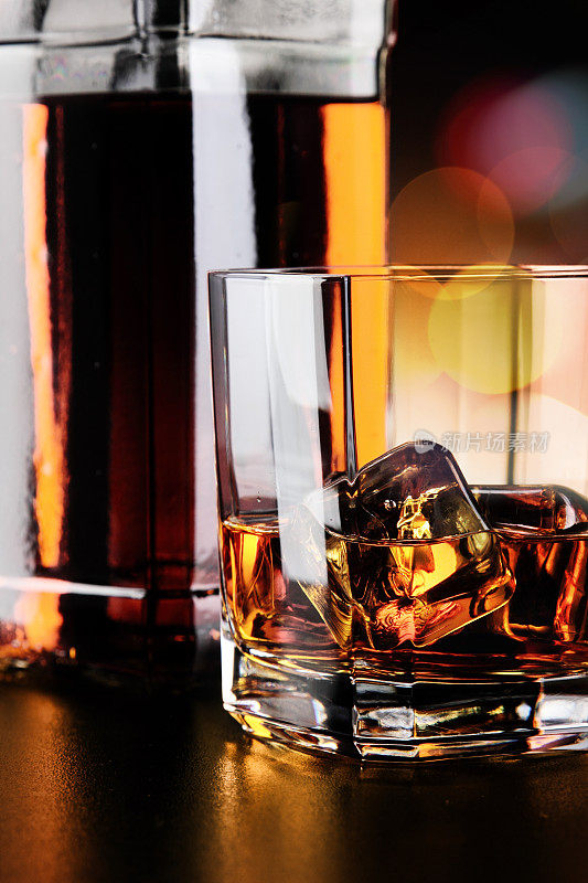 威士忌酒杯和酒瓶放在吧台上
