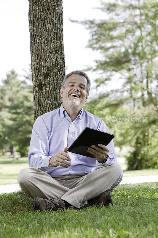 男人笑着阅读电子平板电脑