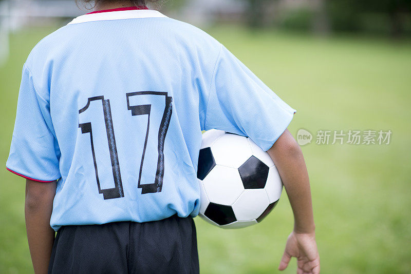 一个小学年龄的男孩站在一边