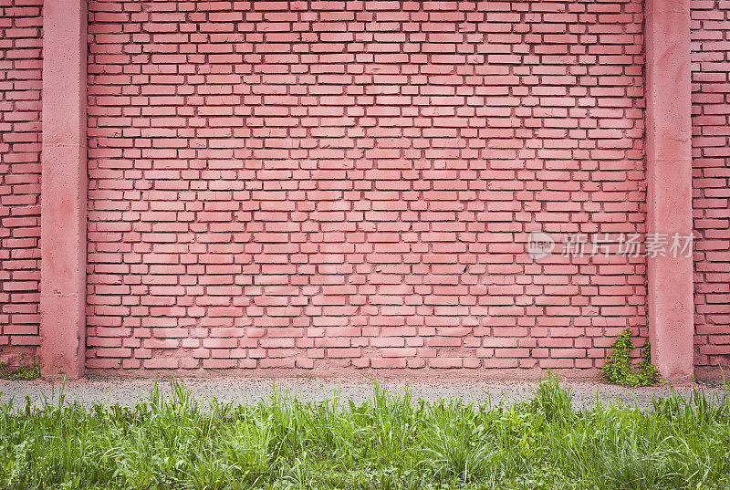 有人行道和草地的红砖墙