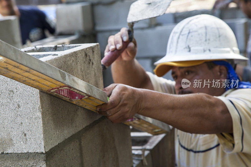 建筑工人检查正在施工的墙体水平