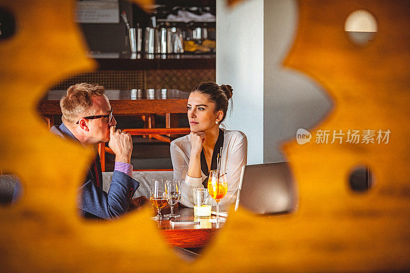 年轻的女商人和男商人在一家餐馆聊天