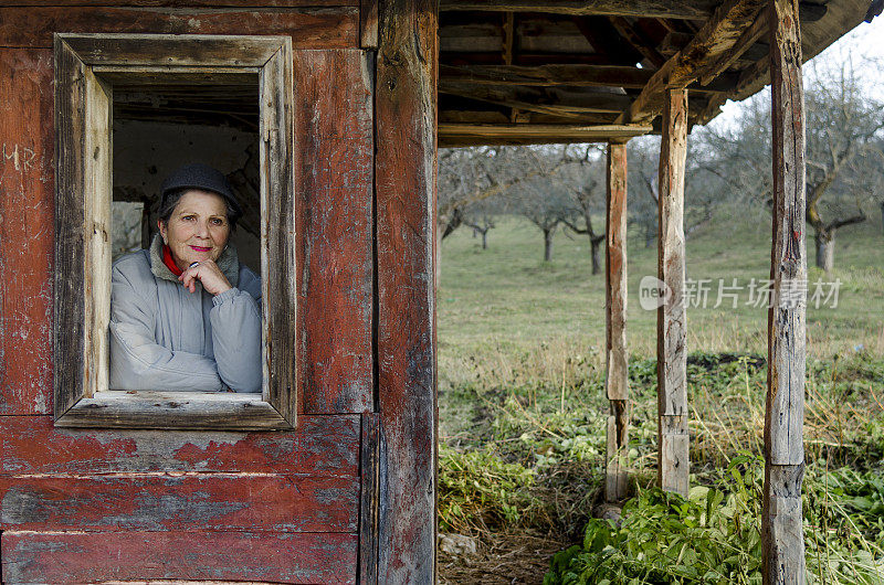 罗马尼亚小屋窗户上的老妇人