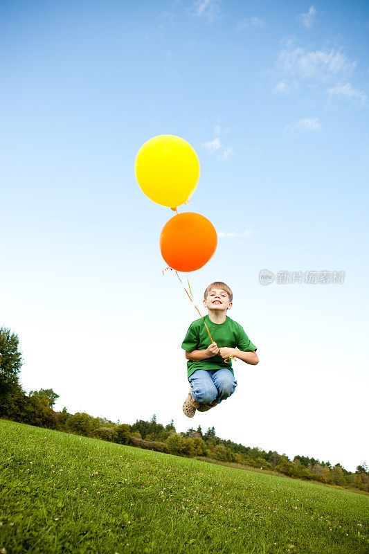 快乐的小男孩和气球在外面跳
