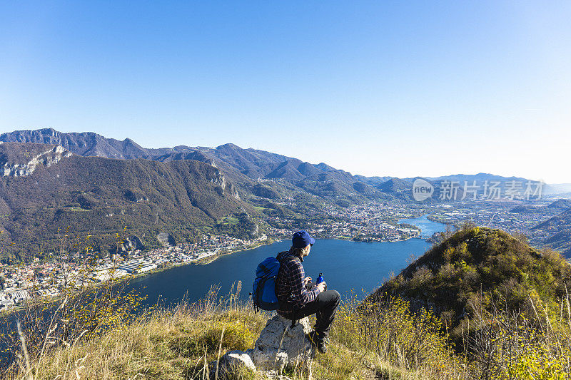 徒步旅行者在山顶喝水瓶