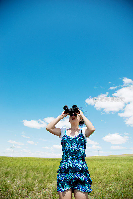 一位妇女用双筒望远镜看天空