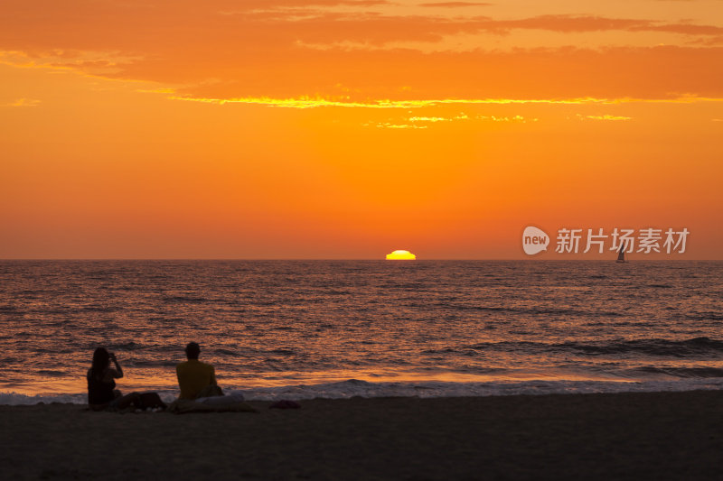 一对夫妇在看日落，在海上航行。